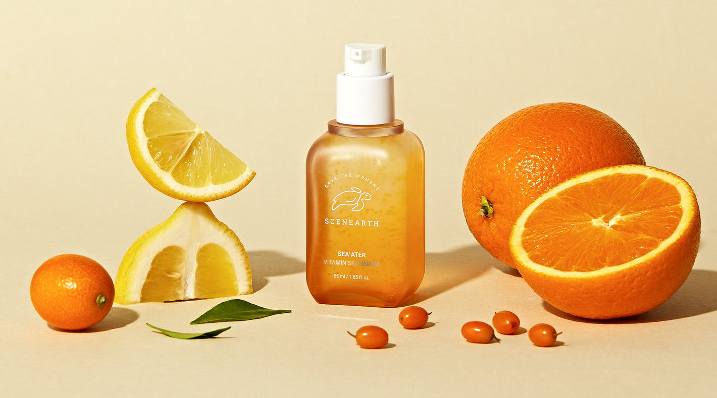 a bottle of Scenearth's essence next to lemons, oranges, and sea buckthorn